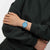 Armbanduhr am Handgelenk: blaues Band, silbernes Gehäuse, blaues Zifferblatt mit goldenen Zeigern