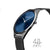 Armbanduhr seitlich mit blauem Zifferblatt und schwarzem Milanaise-Band.