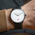 Montre homme avec bracelet en métal noir et cadran blanc, index bâtons fins