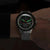 Montre homme sur bracelet métallique avec cadran sombre et accents verts