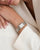 Silberne Armbanduhr am Handgelenk: rechteckiges Gehäuse, Metallgliederarmband, weißes Zifferblatt