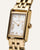 Goldfarbene rechteckige Armbanduhr mit weißem Ziffernblatt, römischen Ziffern und Krone