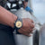 Montre bracelet pour homme au poignet avec cadran beige et bracelet en caoutchouc noir
