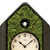 Pendule de maison avec mousse verte, cadran et figurine de coucou sur le dessus