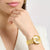 Damenuhr am Handgelenk, goldfarbenes Milanaise-Armband und rundes Zifferblatt