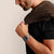 Handgelenkuhr mit silbernem Metallarmband am Unterarm, schwarzes Outfit im Bild