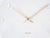 Horloge murale blanche avec aiguilles dorées et chiffres gravés, détail frontal