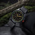 Montre de sport au poignet avec boîtier noir, cadran beige et index luminescents