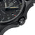 Montre homme de profil : boîtier noir et couronne moletée sur bracelet noir