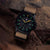 Montre homme avec bracelet textile beige et boîtier noir, cadran vert lumineux