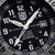 Gros plan d'une montre pour homme : cadran noir avec chiffres blancs, aiguilles lumineuses et affichage de la date 31.