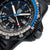 Bracelet pour homme, gros plan : bracelet noir, cadran bleu, aiguilles lumineuses