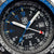 Bracelet pour homme Gros plan : lunette bleu argenté, cadran noir avec index luminescents