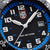 Gros plan du cadran : aiguilles lumineuses blanches, logo LUMINOX, échelle de rehaut bleue, guichet de date