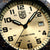 Gros plan du cadran : design beige, logo LUMINOX, date à 3h et aiguilles noires
