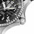 Montre pour homme : détail de la lunette crantée, de la couronne et du cadran noir