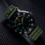 Montre bracelet pour homme, vue de trois quarts, avec index lumineux, bracelet kaki et boîtier noir