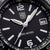 Gros plan : montre pour homme avec cadran noir, aiguilles lumineuses et affichage de la date à 3 heures