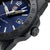 Vue détaillée : montre de plongée bleue avec couronne, lunette moletée et bracelet noir