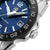 Gros plan d'une montre pour femme : cadran bleu, lunette noire et couronne visible