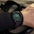 Montre homme au poignet avec bracelet en caoutchouc noir et cadran vert