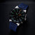 Montre de plongée avec bracelet bleu et cadran noir avec index lumineux verts