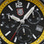 Gros plan du cadran d'une montre de sport pour homme : look noir, lunette jaune, sous-cadrans chronographes