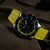 Montre de sport pour homme avec bracelet en silicone jaune, lunette noire avec points lumineux et chronographe