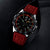 Montre homme avec cadran noir, bracelet en silicone rouge et détails lumineux