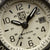 Montre bracelet homme cadran rapproché : chiffres arabes, date à 3h, aiguilles
