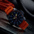 Montre pour homme avec bracelet en caoutchouc orange, lunette noire et chiffres luminescents