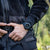 Montre de sport portée au poignet avec bracelet noir et cadran sombre.