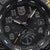 Gros plan du cadran d'une montre bracelet pour homme avec date, aiguilles lumineuses et design noir.