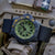 Montre homme sur tissu : boîtier noir, cadran vert, bracelet textile bleu