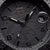 Cadran de montre pour homme avec détails structurés noirs, aiguilles dorées et affichage de la date « 31 ».