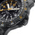 Montre homme avec bracelet noir et lunette crantée sur le boîtier.