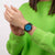 Armbanduhr am Handgelenk mit schwarzem Band und blauem Zifferblatt.