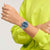 Getragene Armbanduhr mit silbernem Band und blauem Zifferblatt an Hand