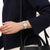 Armbanduhr am Handgelenk mit weißem Armband, cremefarbenem Zifferblatt und Kristalllünette