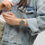 Swatch Herrenarmbanduhr am Handgelenk mit orangefarbenem Band auf Jeans