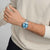 Swatch Chronograph am Handgelenk mit Edelstahlarmband und blauem Zifferblatt