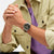 Swatch Chronographen-Armbanduhr am Handgelenk mit braunem Lederband, leuchtenden Zeigern