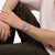 Damenuhr am Handgelenk mit pinkem Silikonarmband und grün-pinkem Zifferblatt