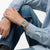 Herrenarmbanduhr am Handgelenk mit blauem Armband und silbernem Gehäuse
