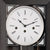 Gros plan du cadran d'une horloge murale avec une échelle blanche, des aiguilles noires et des chiffres romains