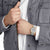 Montre unisexe Mondaine au poignet avec bracelet gris et boîtier doré, cadran gris