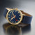 Montre Mondaine avec cadran bleu, boîtier doré et bracelet textile bleu