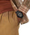 Montre homme au poignet, boîtier numérique noir et bracelet en caoutchouc, sous une chemise à carreaux