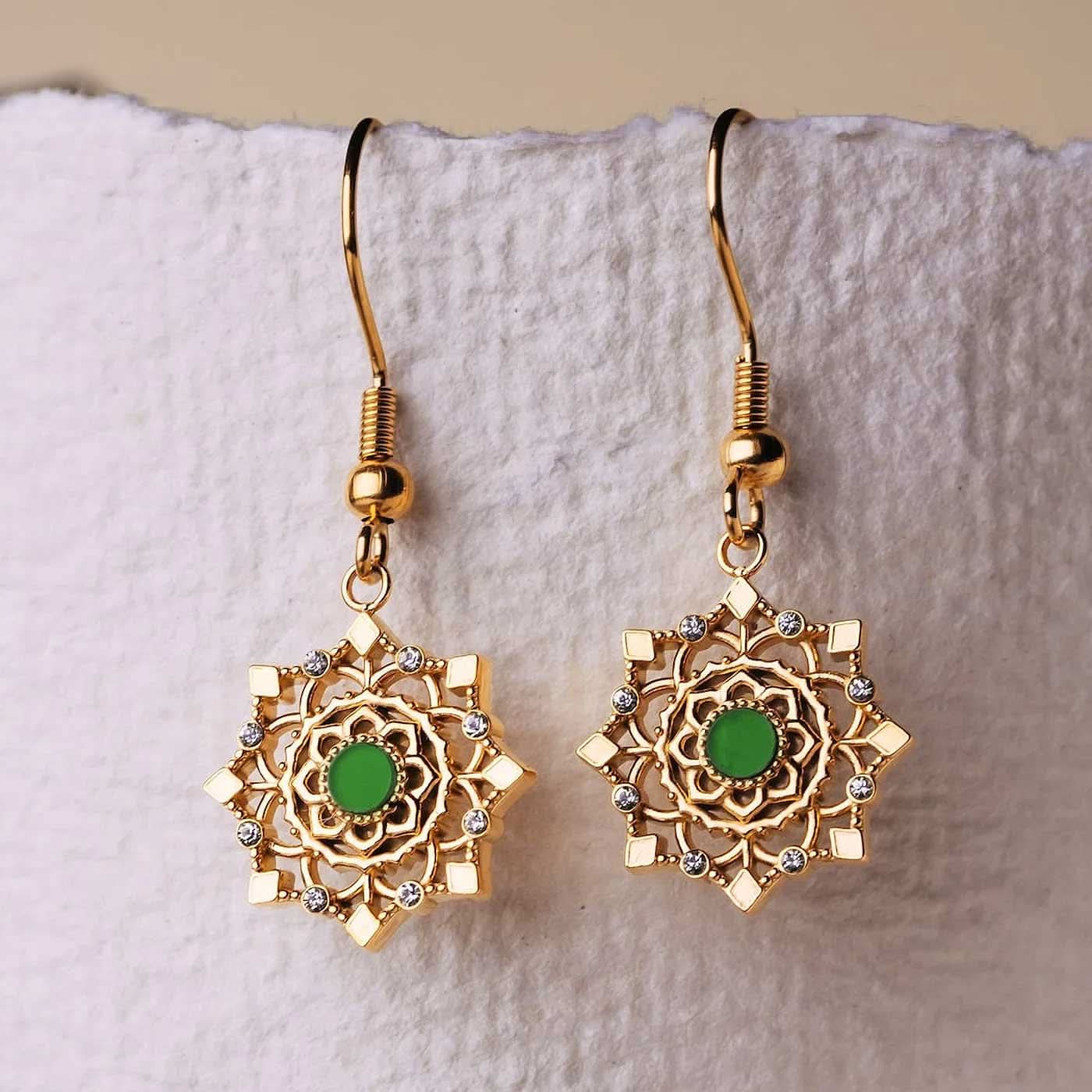 Paire de pendants d'oreilles dorés avec un insert rond vert et des pierres scintillantes.