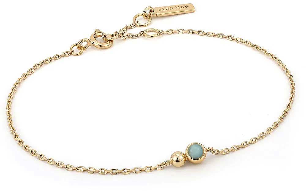 Bracelet doré à maillons et petites breloques sphériques, pierre bleue
